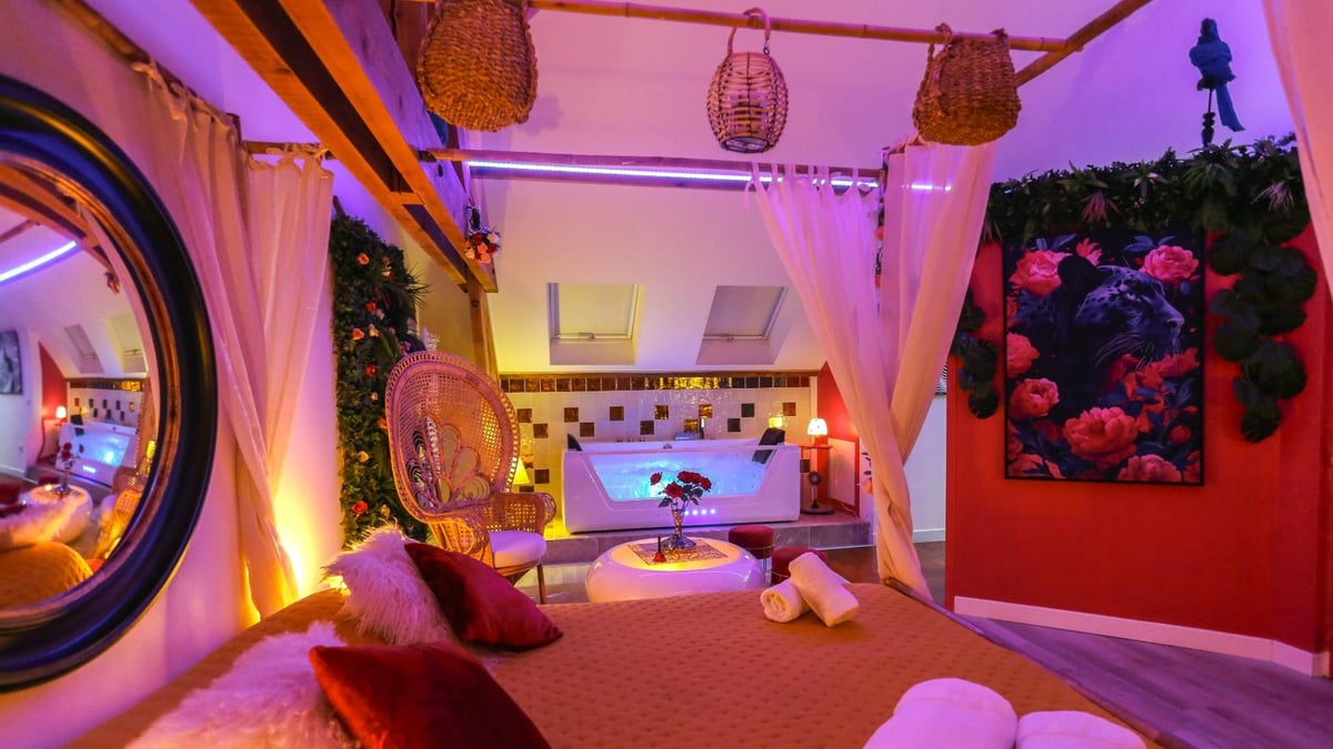 Lit à baldaquin et jacuzzi de la love room Tentations à Amiens